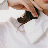 Close-up of a person wearing a white shirt with a high collar.